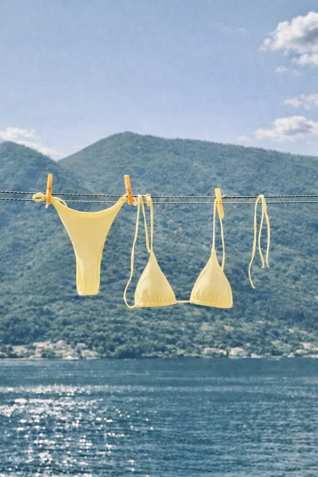 Yellow bikinis on a clothesline against blue hills