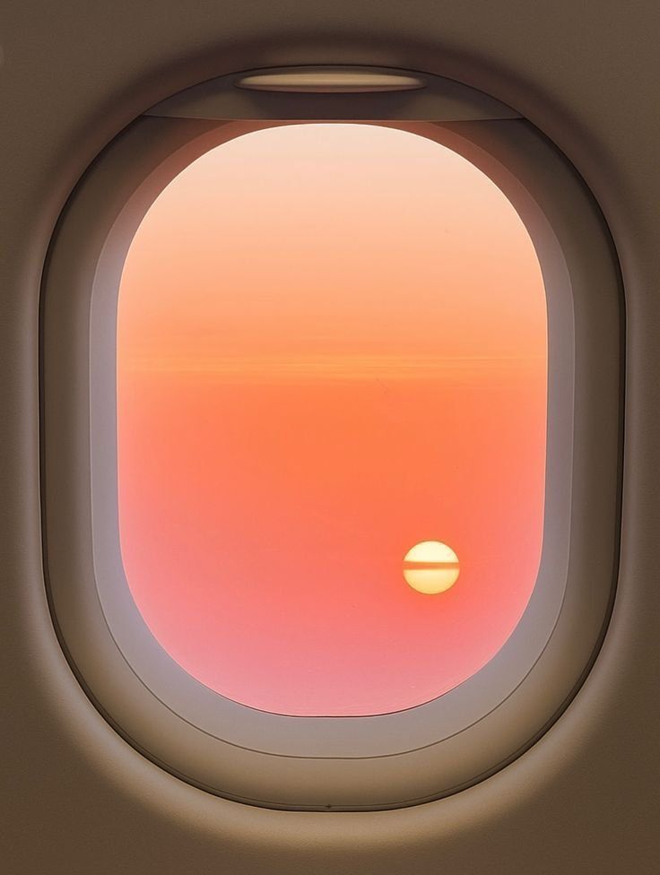 Airplane window sunset over clouds